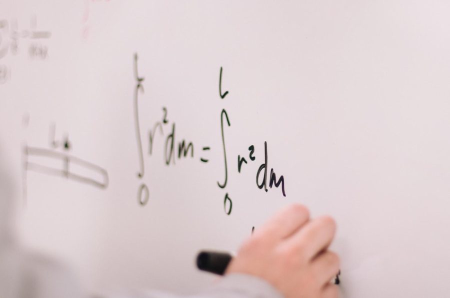 Student doing math on white board