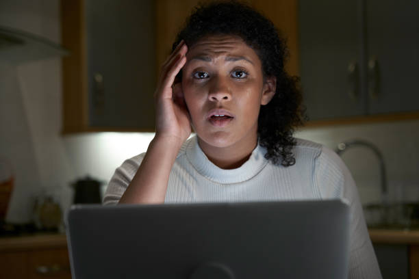 Portrait Of Unhappy Woman At Home With Computer Victim Of Online Crime