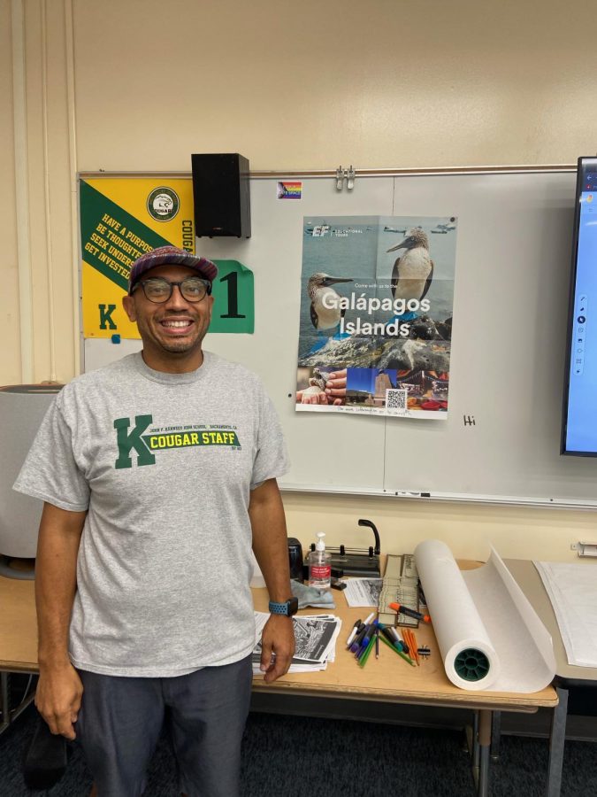 AP World History PACE teacher Jonathan Andrews with announcement poster to the Galápagos Islands. Photo by Kaili Jiang. John F. Kennedy High School.